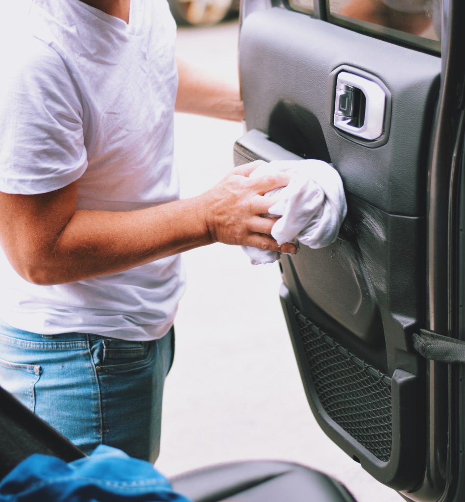 Man is cleaning inside of a car